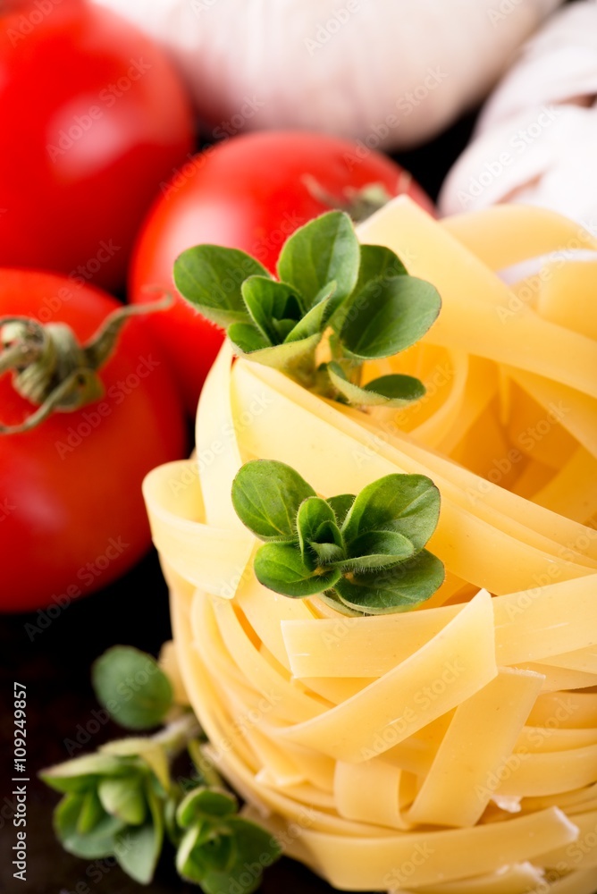 Three stigs of oregano on portion of fettuccine pasta
