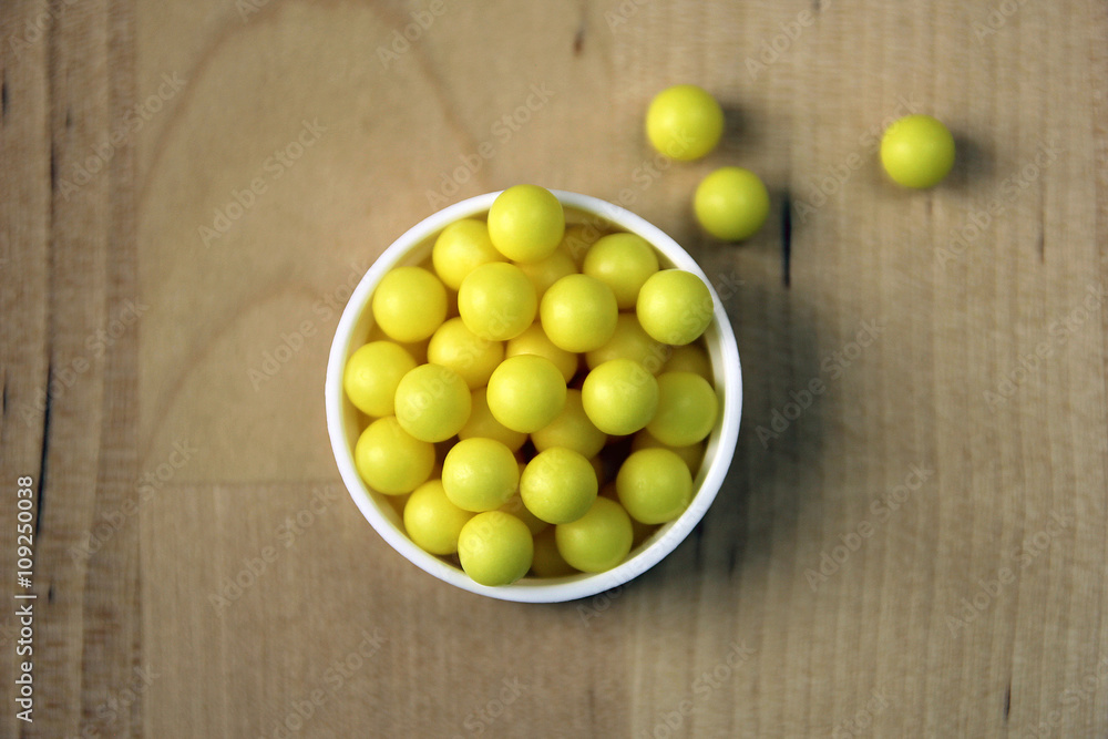 handful of many round yellow vitamin C dragee pills closeup on w handful of many round yellow vitamin C dragee pills closeup on w