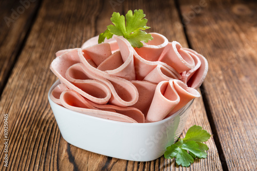 Sliced Mortadella on wooden background