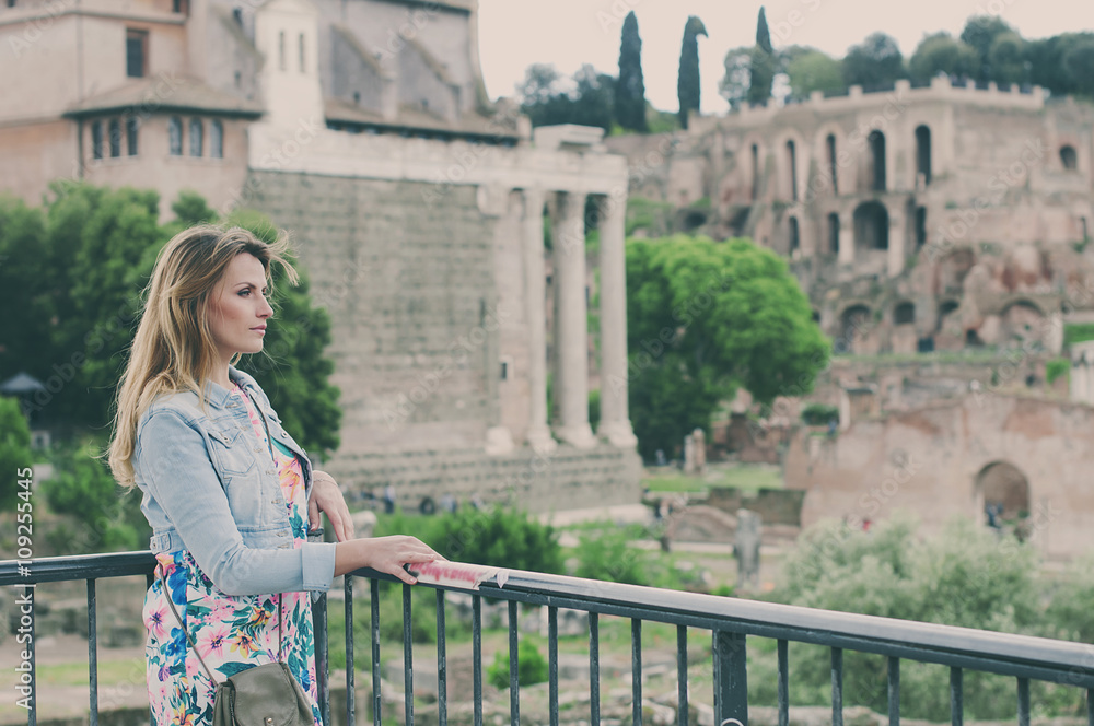 Pretty female tourist on the ruins of the Roman Forum in Rome, I