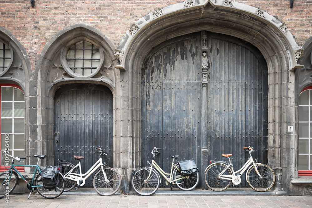 Bicycles leaning against old wooden door