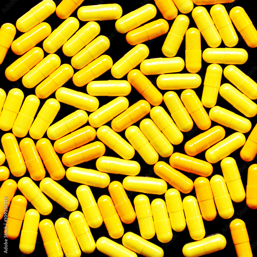 Yellow pills on black background Yellow pills on black background