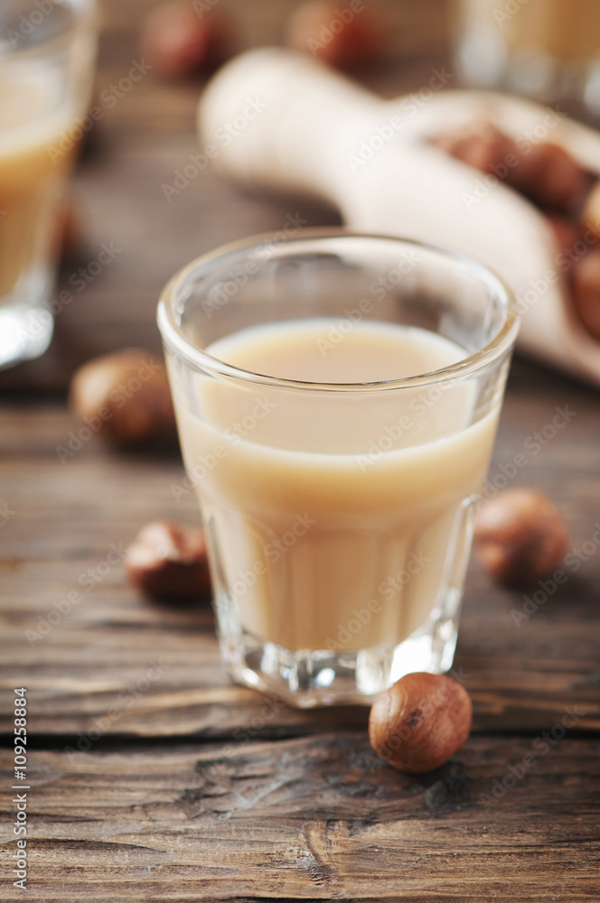 Italian traditional hazelnut liqueur on the wooden table Italian traditional hazelnut liqueur on the wooden table
