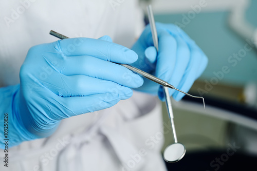 close-up of dentist hand with dental tools