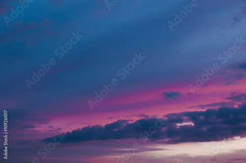 Dramatic purple sunset sky with blue colored clouds.
