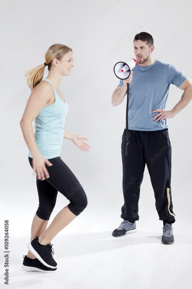 Trainer motiviert Sportlerin mit Megafon Porträt Trainer motiviert Sportlerin mit Megafon Porträt