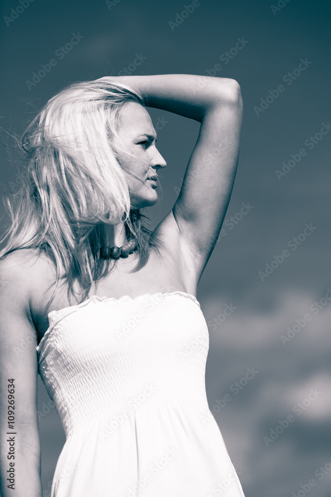 Naklejka premium Beauty blonde woman portrait on sky background.
