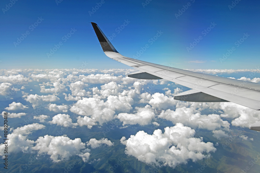 Obraz premium aircraft wing flying over beautiful clouds