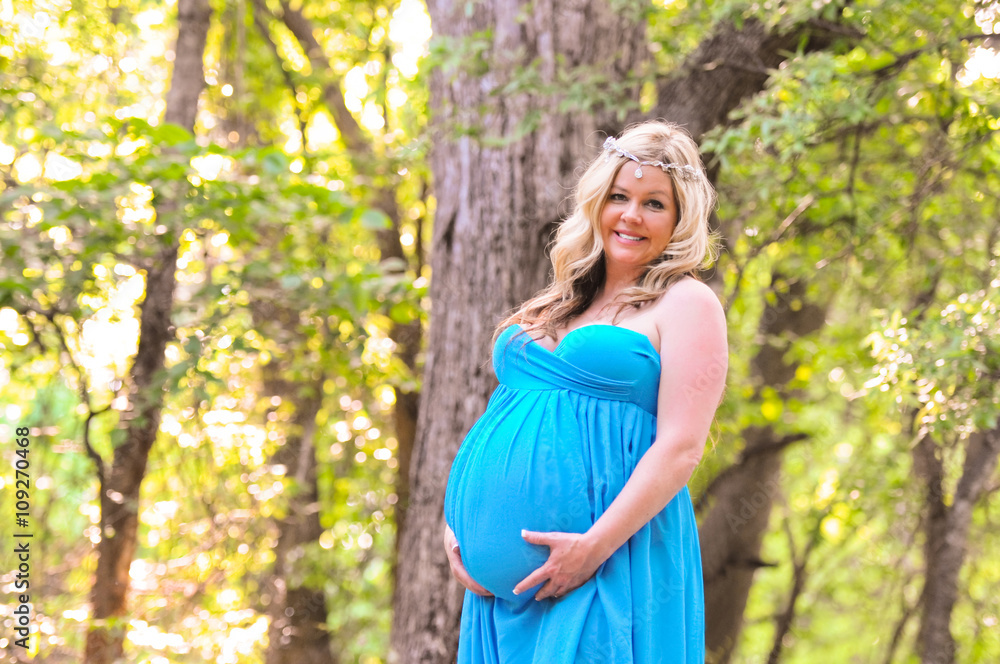 Beautiful pregnant woman in teal dress outdoors. Beautiful pregnant woman in teal dress outdoors.