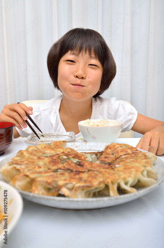 餃子を美味しそうに食べる女の子