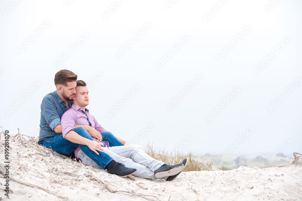 Gay men embracing on a beach
