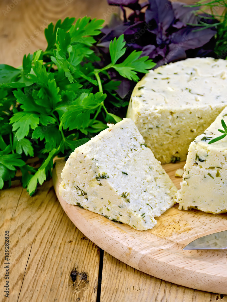 Cheese homemade round with herbs on board