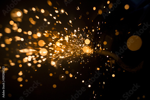 Fotografie, Obraz Glowing flow of steel metal spark dust particles and bokeh shine in the dark bac