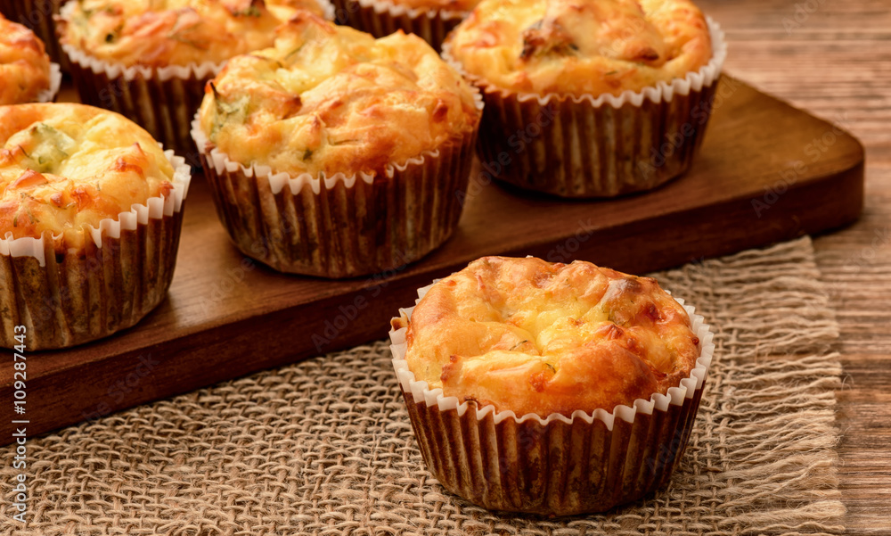 Homemade muffins with chicken and cheese on brown wooden board. Homemade muffins with chicken and cheese on brown wooden board.