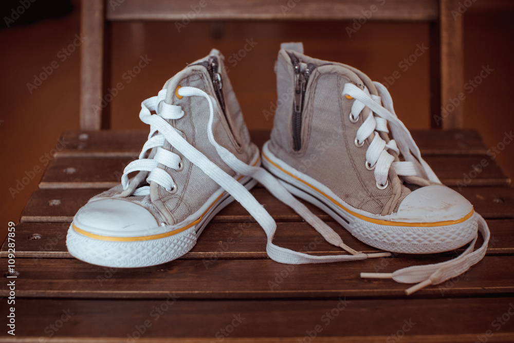 Gray baby sneakers on wooden background
