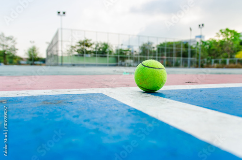 Tennis ball on concrete floor.Top view old concrete tennis court © Zenzeta