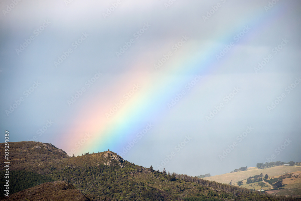 Detail of rainbow with landscape of South island, New Zealand