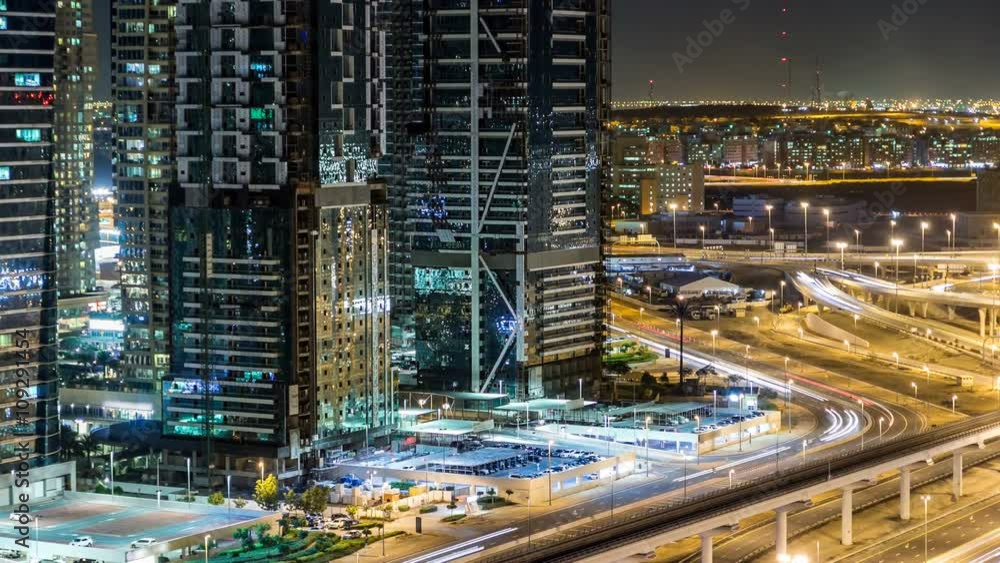 Buildings of Jumeirah Lakes Towers with traffic on the road night timelapse. Buildings of Jumeirah Lakes Towers with traffic on the road night timelapse.