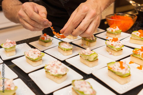cook put caviar on delicious gourmet canape starters