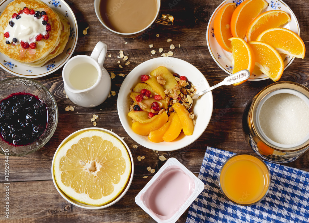 Breakfast pancakes, cereal, fruit and coffee on a wooden table. Breakfast pancakes, cereal, fruit and coffee on a wooden table.