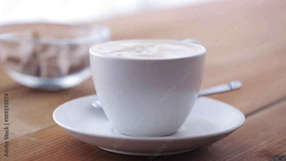 cream pouring to coffee cup on wooden table