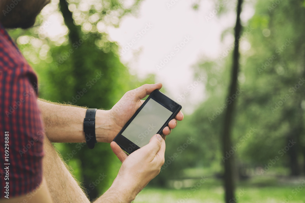 Man using cellphone outdoors.
