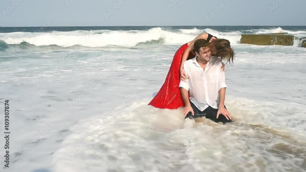 Young attractive couple sitting on beach kissing Young attractive couple sitting on beach kissing