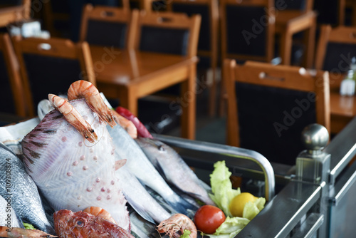 Different kind of fishes and shrimps are in a seafood restaurant. photo