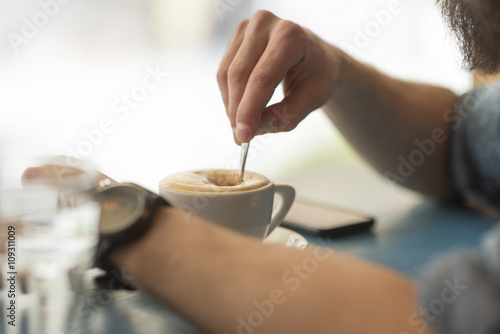 Close up of young man drinking coffee at the coffee shop