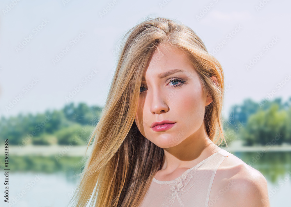     Sexy blonde girl on the lake shore, close up portrait, blurred background, nature 