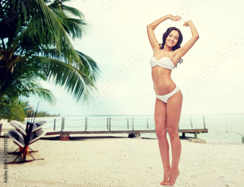 happy young woman in white bikini swimsuit