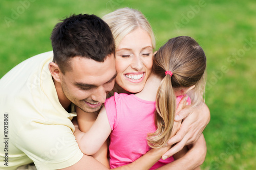 happy family hugging outdoors © Syda Productions