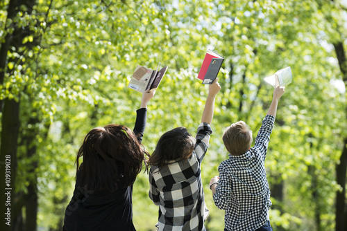 Nastolatki z radością czytają książki w parku wiosną na świeżym powietrzu
