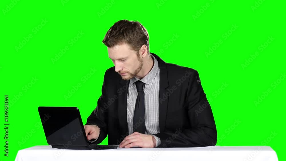 Businessman sitting at the table and uses notebook. Green screen Businessman sitting at the table and uses notebook. Green screen