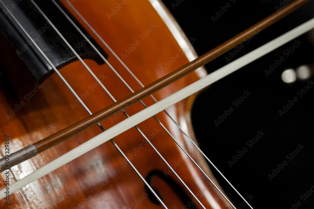 The fiddlestick on the strings of the cello closeup The fiddlestick on the strings of the cello closeup