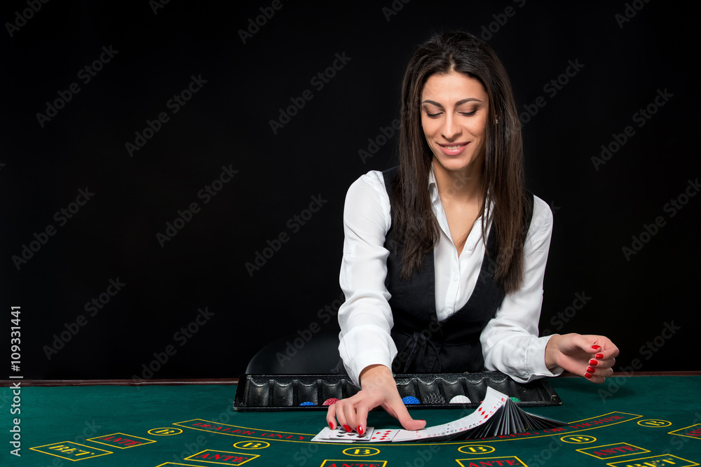 The beautiful girl, dealer, behind a table for poker The beautiful girl, dealer, behind a table for poker