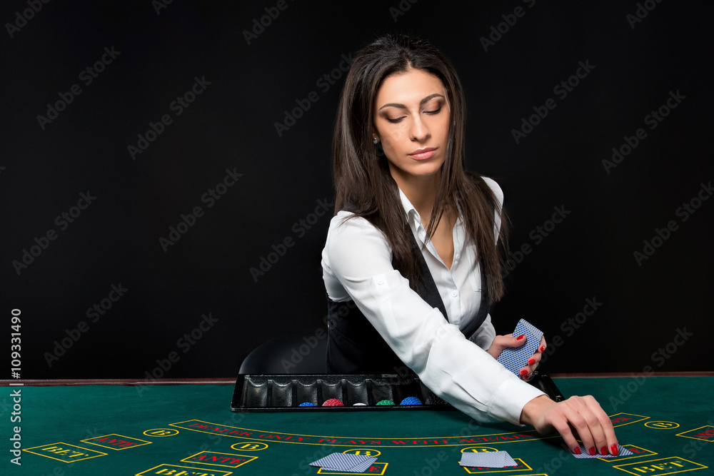 The beautiful girl, dealer, behind a table for poker The beautiful girl, dealer, behind a table for poker