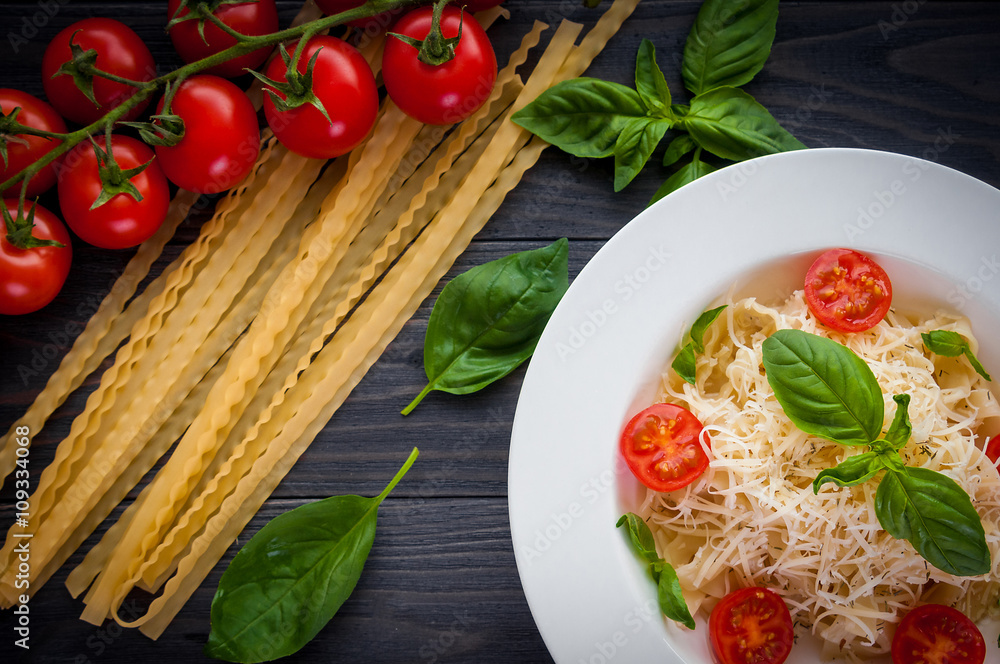 plate of italian pasta with tomatoes, basil and cheese