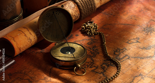 Old vintage retro compass on ancient world map. Vintage still li