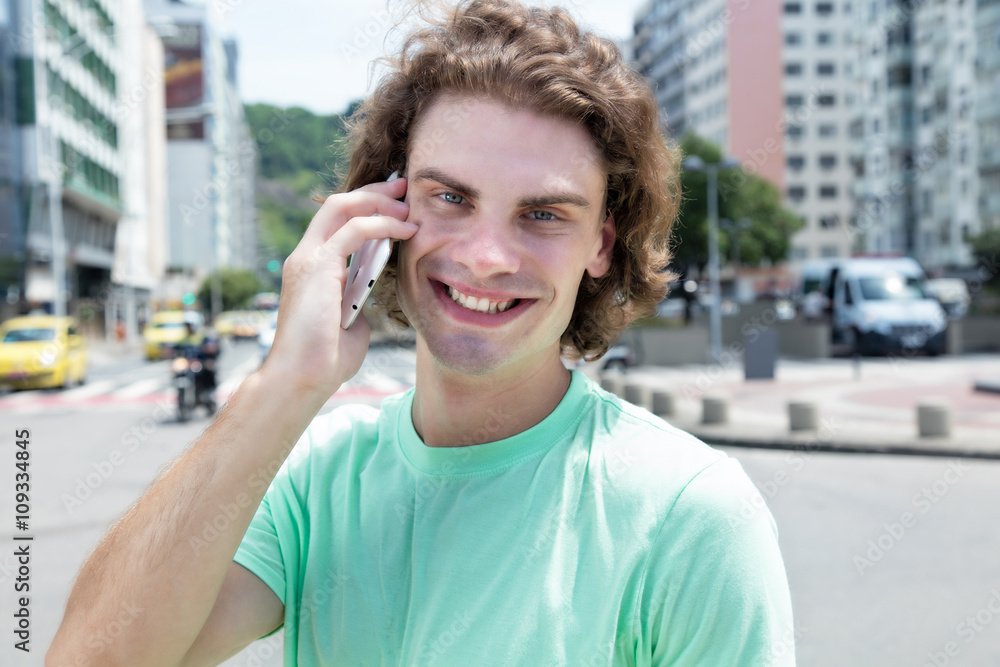 Mann mit langen Haaren am Telefon in der Stadt Mann mit langen Haaren am Telefon in der Stadt