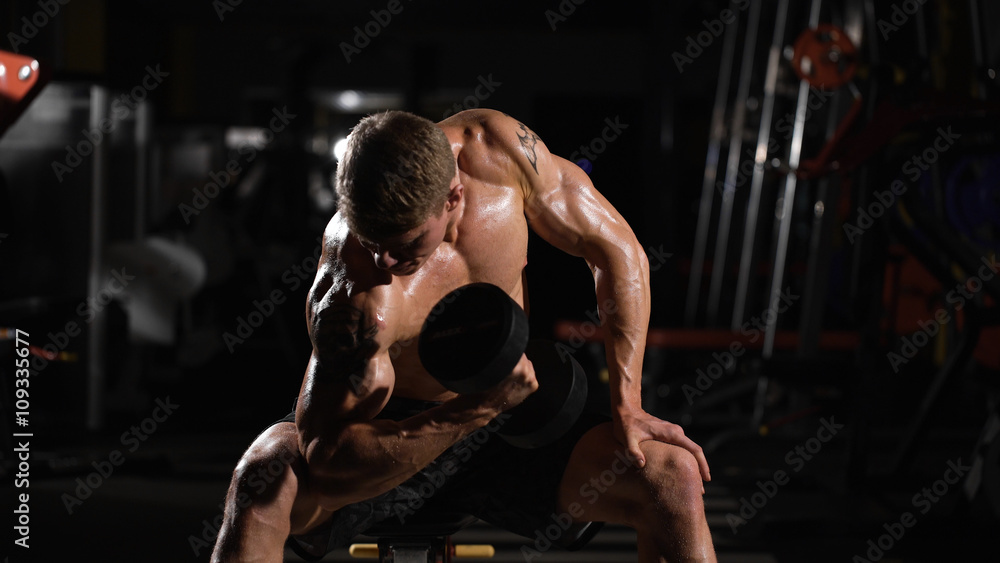 excellent result. handsome young man doing exercises for the biceps excellent result. handsome young man doing exercises for the biceps