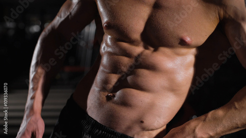 Bodybuilder man with perfect abs, shoulders,biceps, triceps and chest .