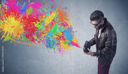 Hipster guy with camera and paint splash