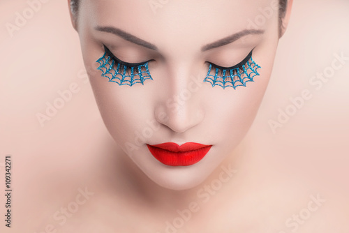 Beauty fashion model woman face. Portrait with red sexy lips and blue false eyelashes