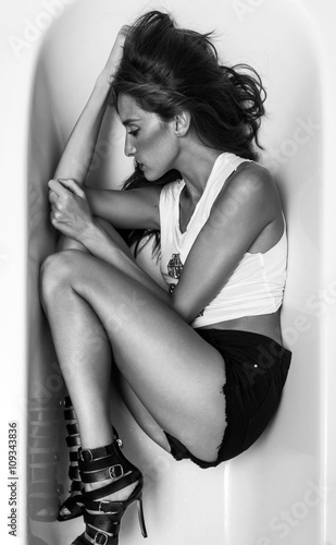 Fotografie, Obraz Woman portrait in fetal position in the bathtub monochrome