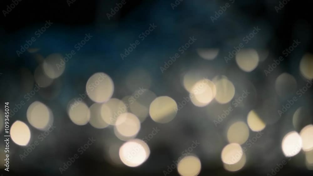 Blurred bokeh white and golden lights from rapidly twinkling fairy lights on black background. Blurred bokeh white and golden lights from rapidly twinkling fairy lights on black background.