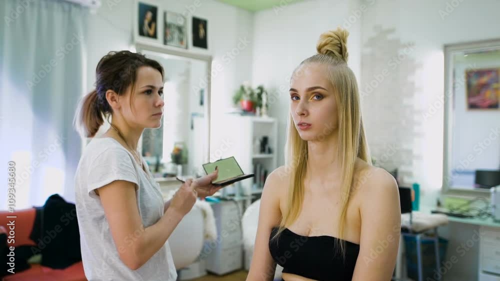 Transformation. In the trendy beauty salon, a professional makeup artist prepares the image for an attractive blonde. Transformation. In the trendy beauty salon, a professional makeup artist prepares the image for an attractive blonde.