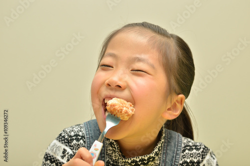 Plakat w ramie 鶏のから揚げを美味しそうに食べる女の子