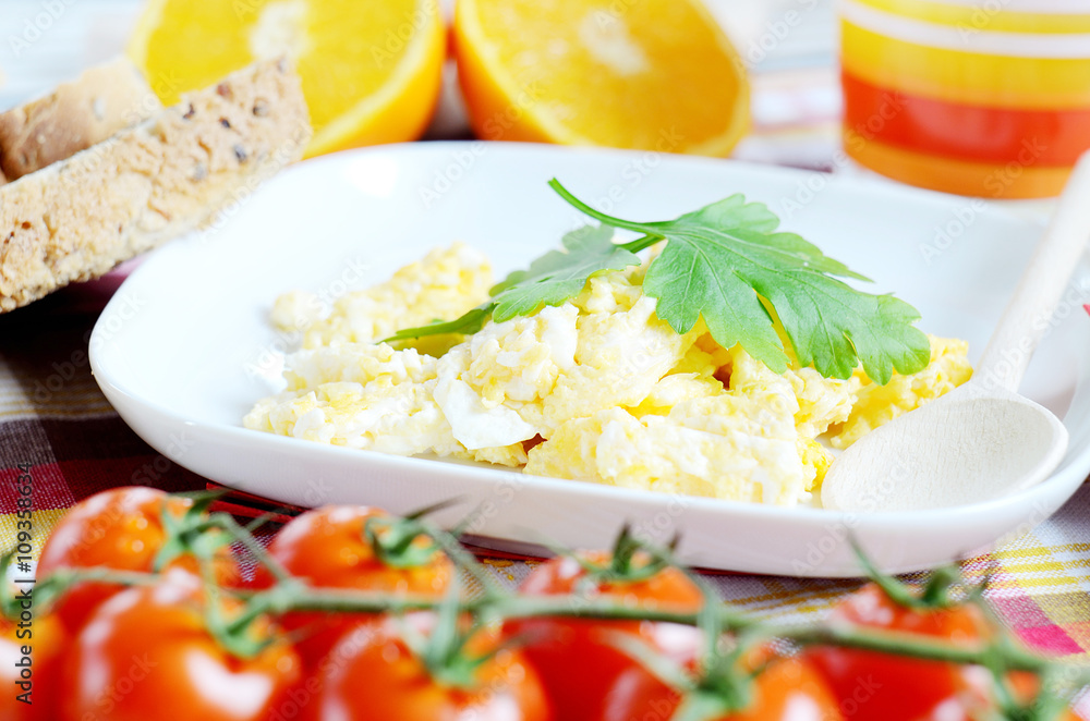 Scrambled eggs, toast bread, fresh juice, tomatoes and oranges Scrambled eggs, toast bread, fresh juice, tomatoes and oranges