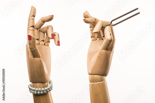 Hand with pitch and hand of singer. Tunnig fork in steel.  On white background. photo